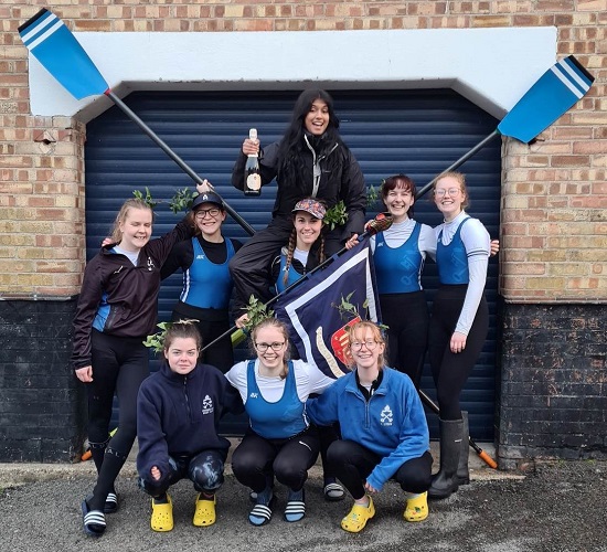 W1 crew posing with blades outside of Peterhouse Boat Club after winning in Lent Bumps 2023