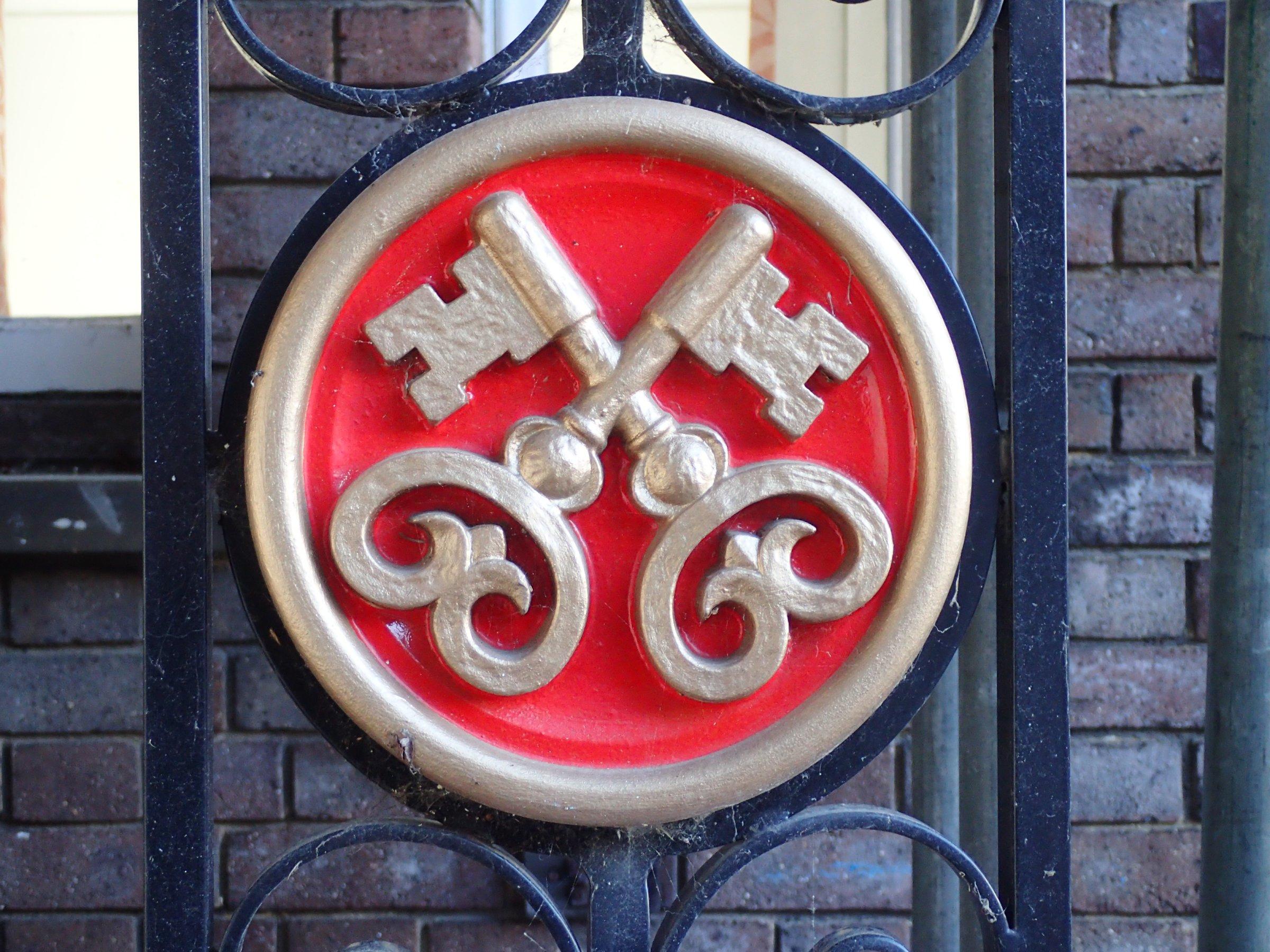 The cross-keys logo on a gate